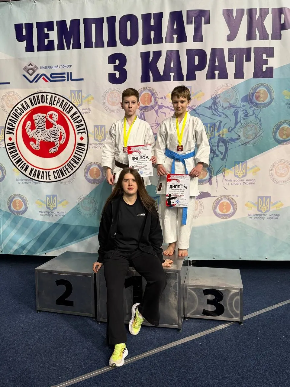 Аліна Павлюк біля п’єдесталу з учнями DZEN на чемпіонаті України з карате