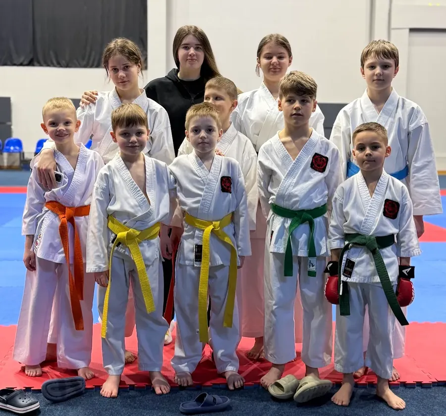 Ученики DZEN KARATE CLUB с цветными поясами стоят вместе на татами