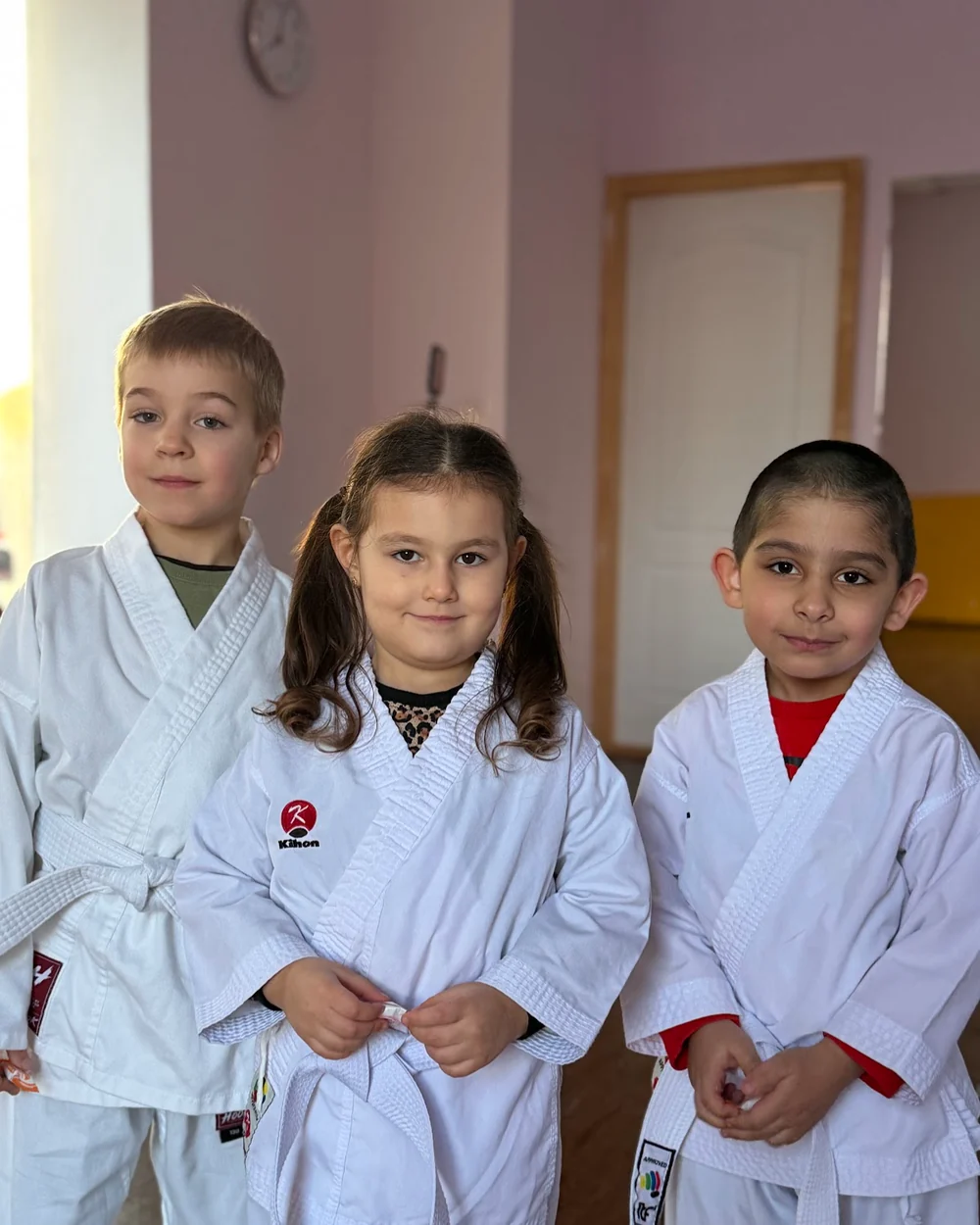 Діти в кімоно з білими поясами перед тренуванням з карате в DZEN KARATE CLUB