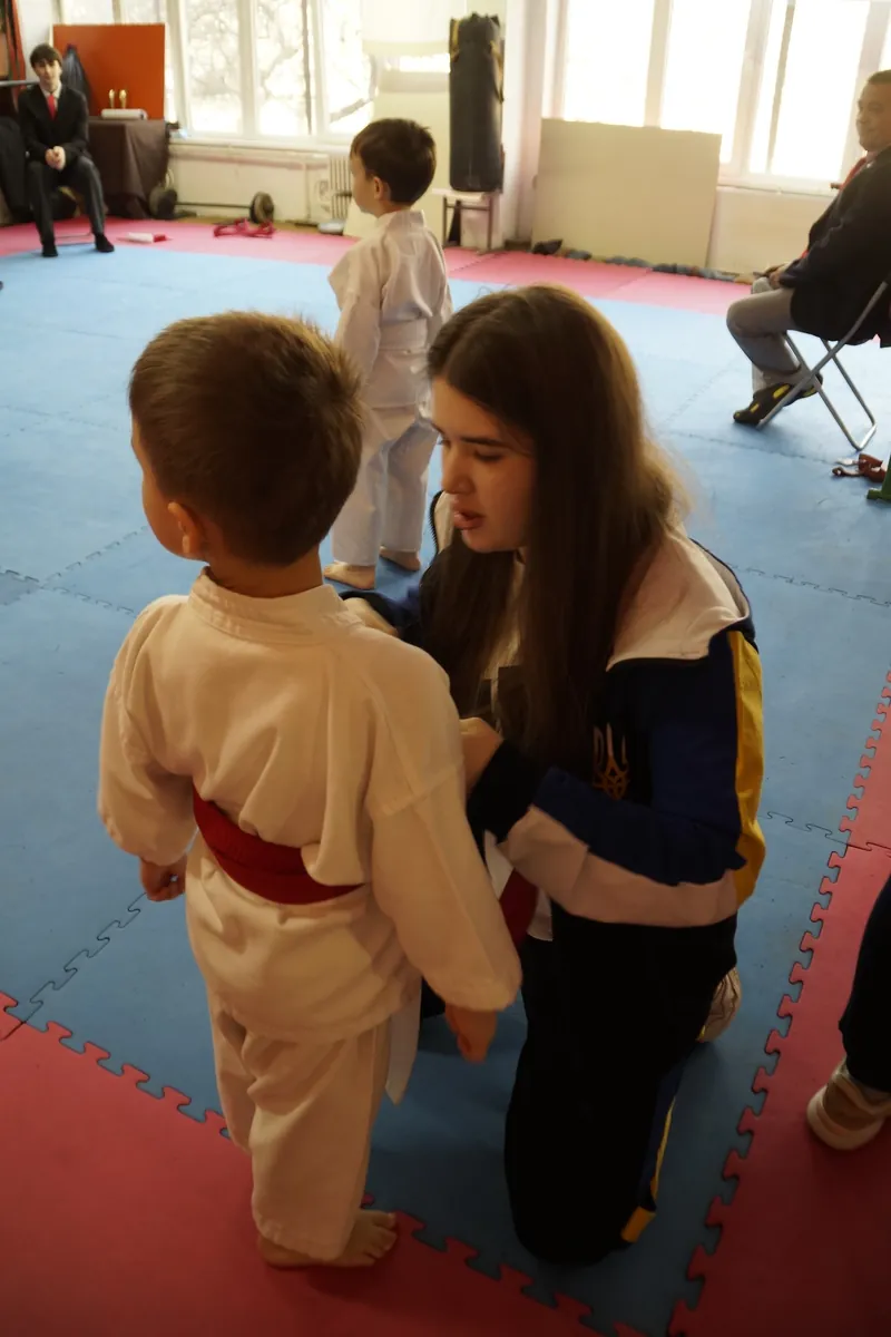 Тренер Аліна Павлюк розмовляє з малим учнем DZEN KARATE CLUB перед виходом на татамі