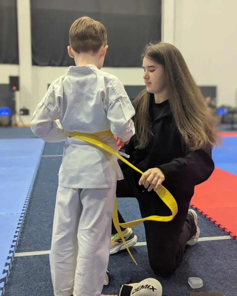 Тренер DZEN KARATE CLUB завязывает пояс ученику