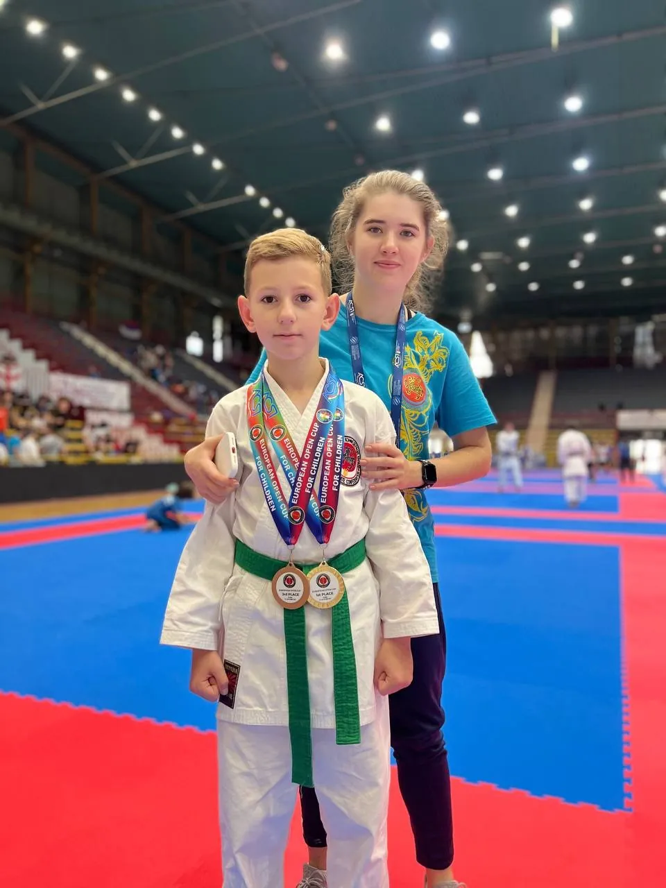 Юний спортсмен DZEN KARATE CLUB з медалями поруч зі спортсменкою клубу