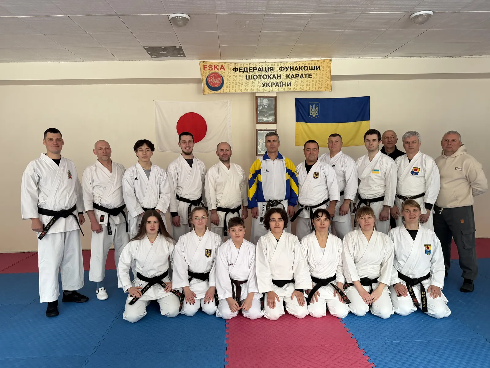 Спортсмени й тренери шотокан карате на спільному фото під прапорами Японії та України